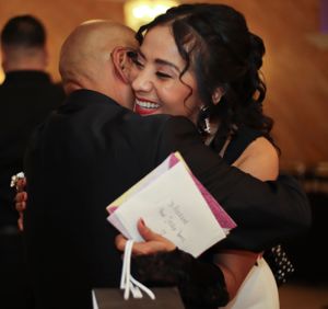 An emotional embrace at what appears to be a formal celebration event.