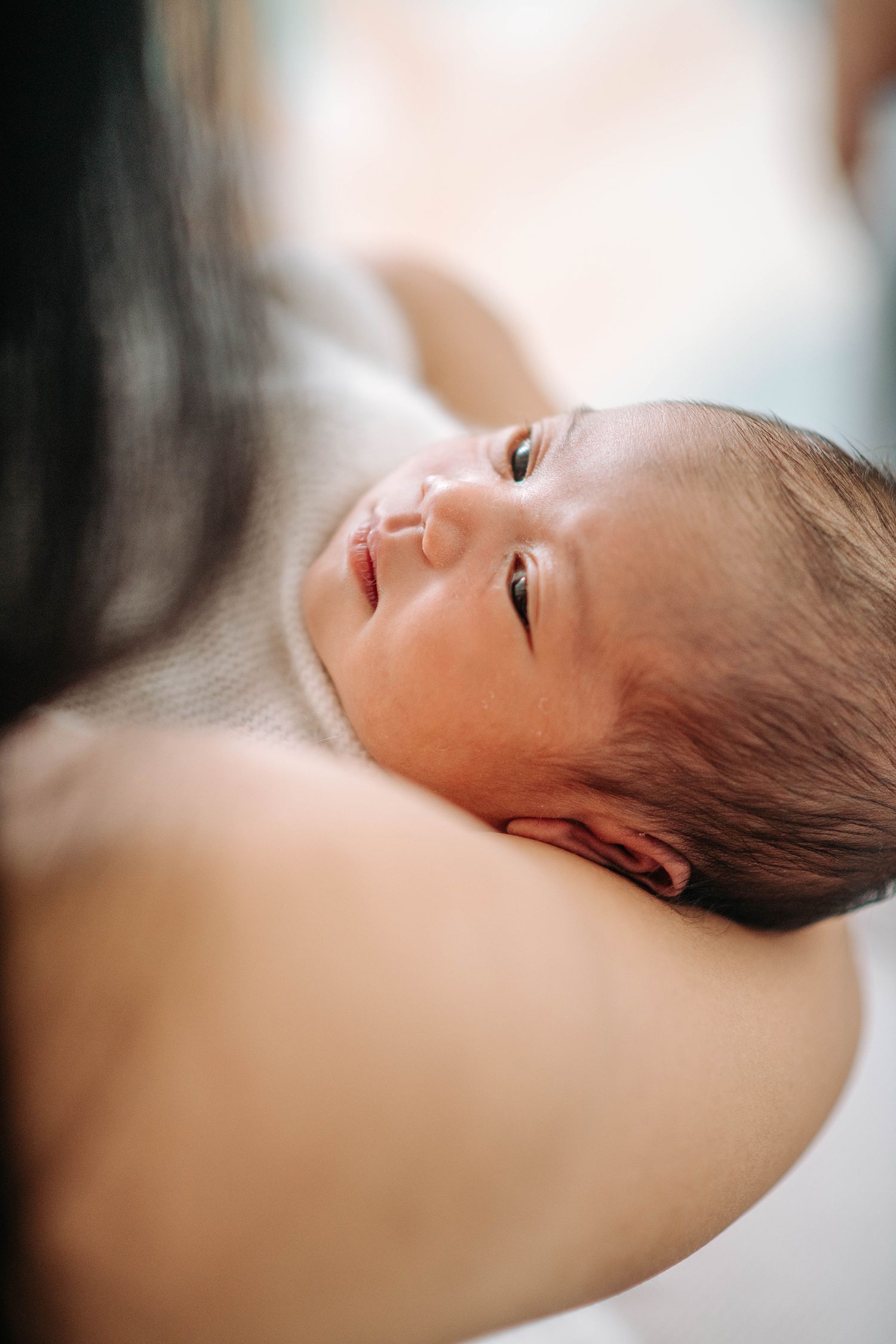 Close-up of a newborn baby's face during an intimate moment.