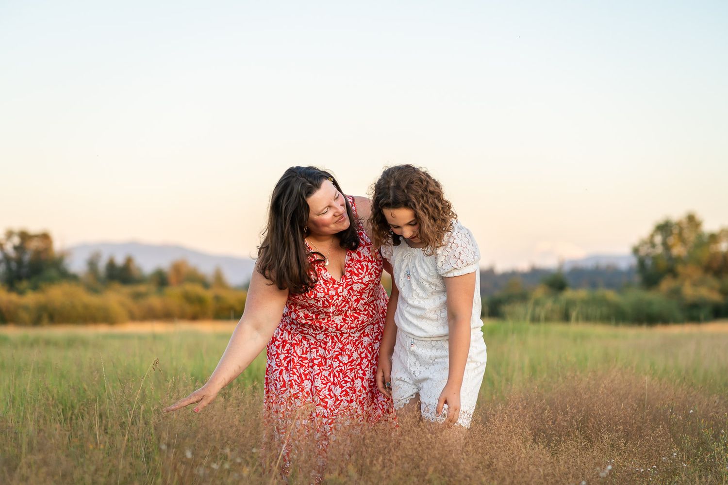 Mother and daughter play in a field of grass in Redmond