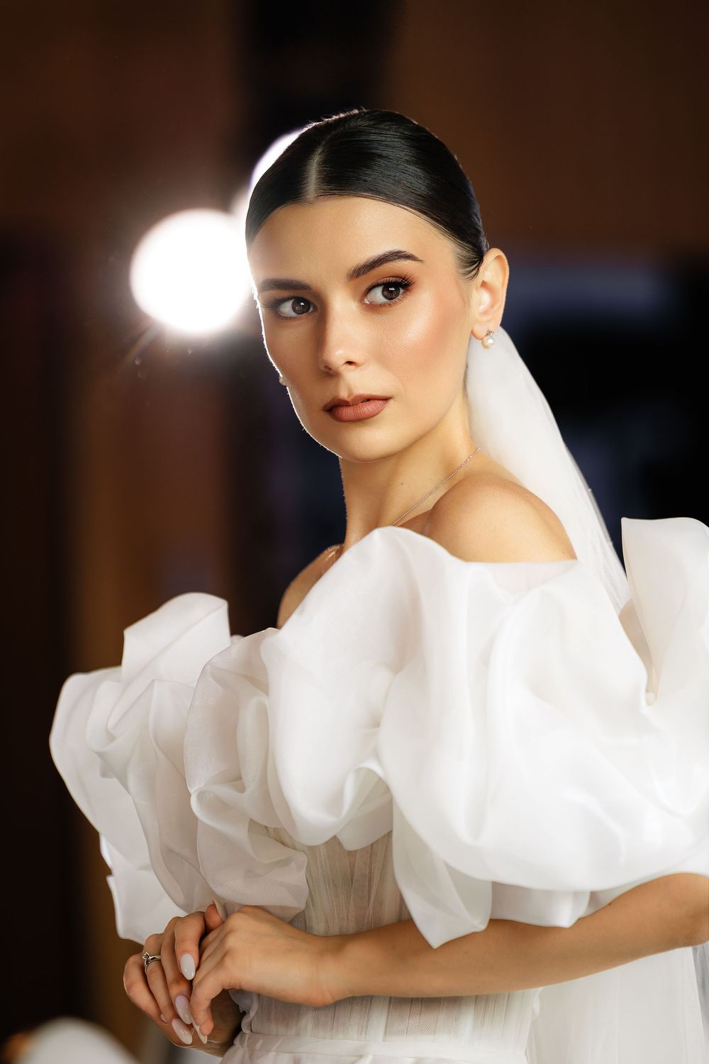 Elegant bridal fashion shots featuring ruffled white dress details and dramatic lighting.