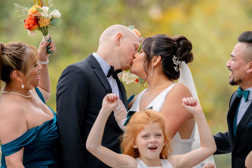 Wedding photoshoot service in Washington, DC. Wedding party members share joyful laughter and embraces during outdoor celebration photos.
