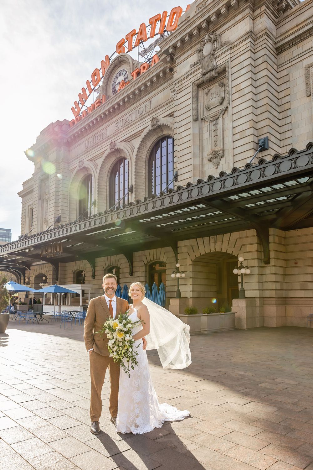 Bride and groom pose outside historic Union Station building on their wedding day in Denver, Colorado.