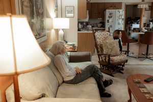 A panoramic view of a cozy living room interior with soft lighting, armchairs, and traditional decor.