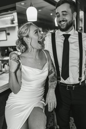 Candid moment of laughter shared between couple at retro diner counter.