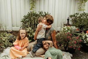 A casual outdoor family moment in a garden with blooming flowers.