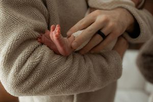 Close-up of hands wearing cozy beige knit sweaters.