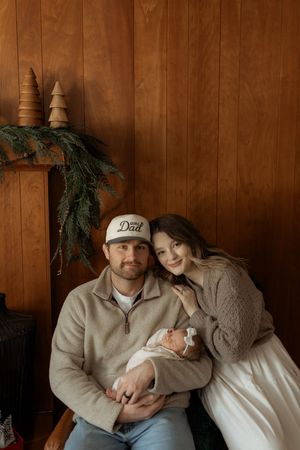 Cozy indoor family photos against wooden paneling with evergreen decorations.