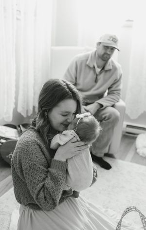 An intimate black and white photograph capturing a tender moment between family members.