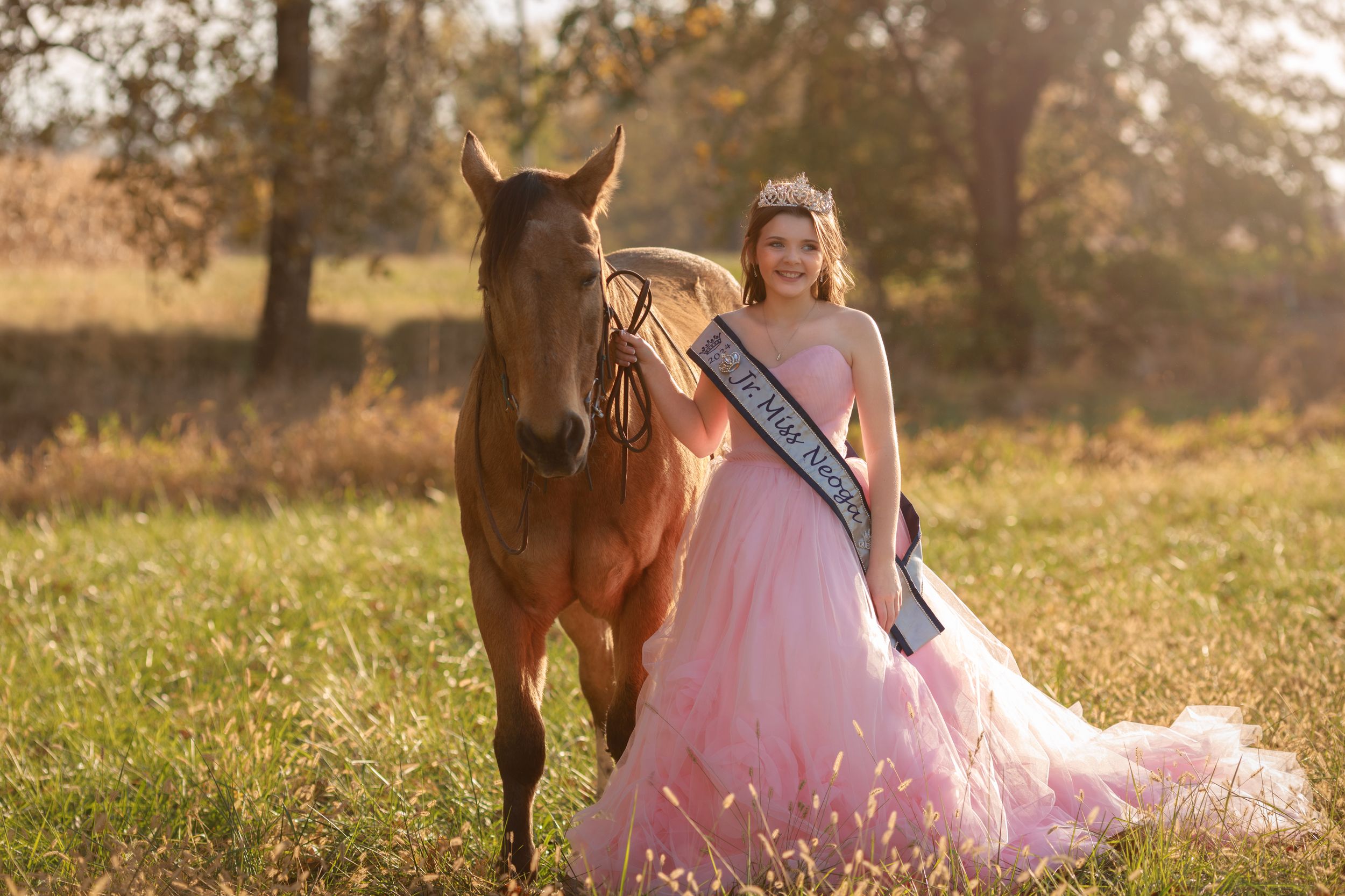 Summer sunset vibes for this girl dressed in pink princess dress with her pretty dun horse.