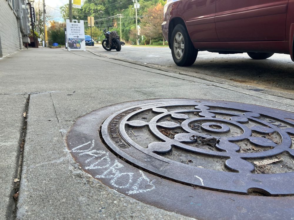 A series of ornate manhole covers with decorative patterns and designs on a city street.