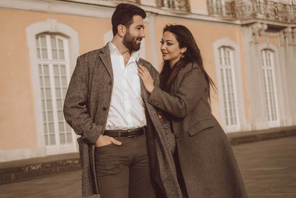 ein Paar mit Blumenstrauß in Hand und lachen zusammen in einer Verlobung Fotoshooting in Brühler Schloss, NRW, Detuschland.