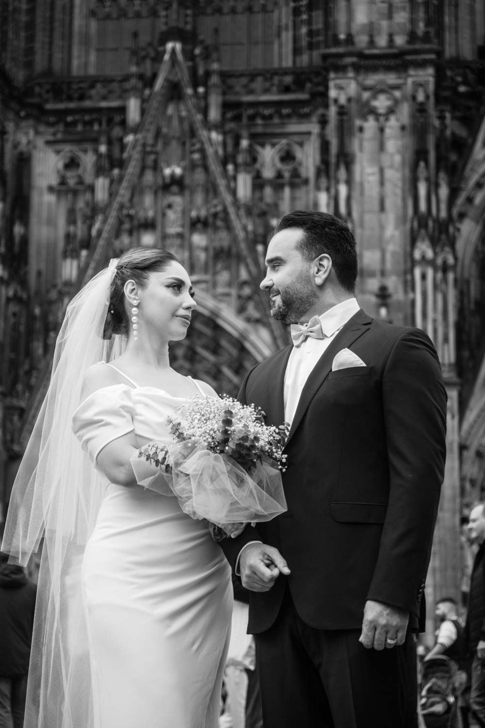 ein Paar in einem Hochzeit Fotoshooting vor Dom in Köln Stadt. ein Schwarz und weiß Foto in einem Trauung Fotoshooting.