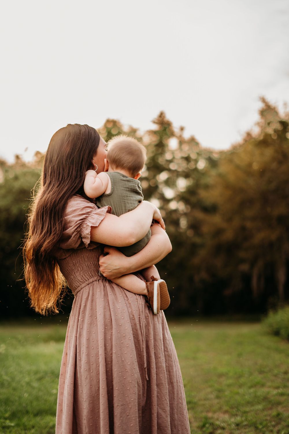 Mother holding infant while looking away.