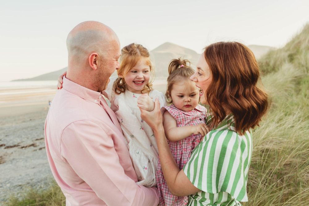 Family sharing loving moments together on coastal path at sunset.