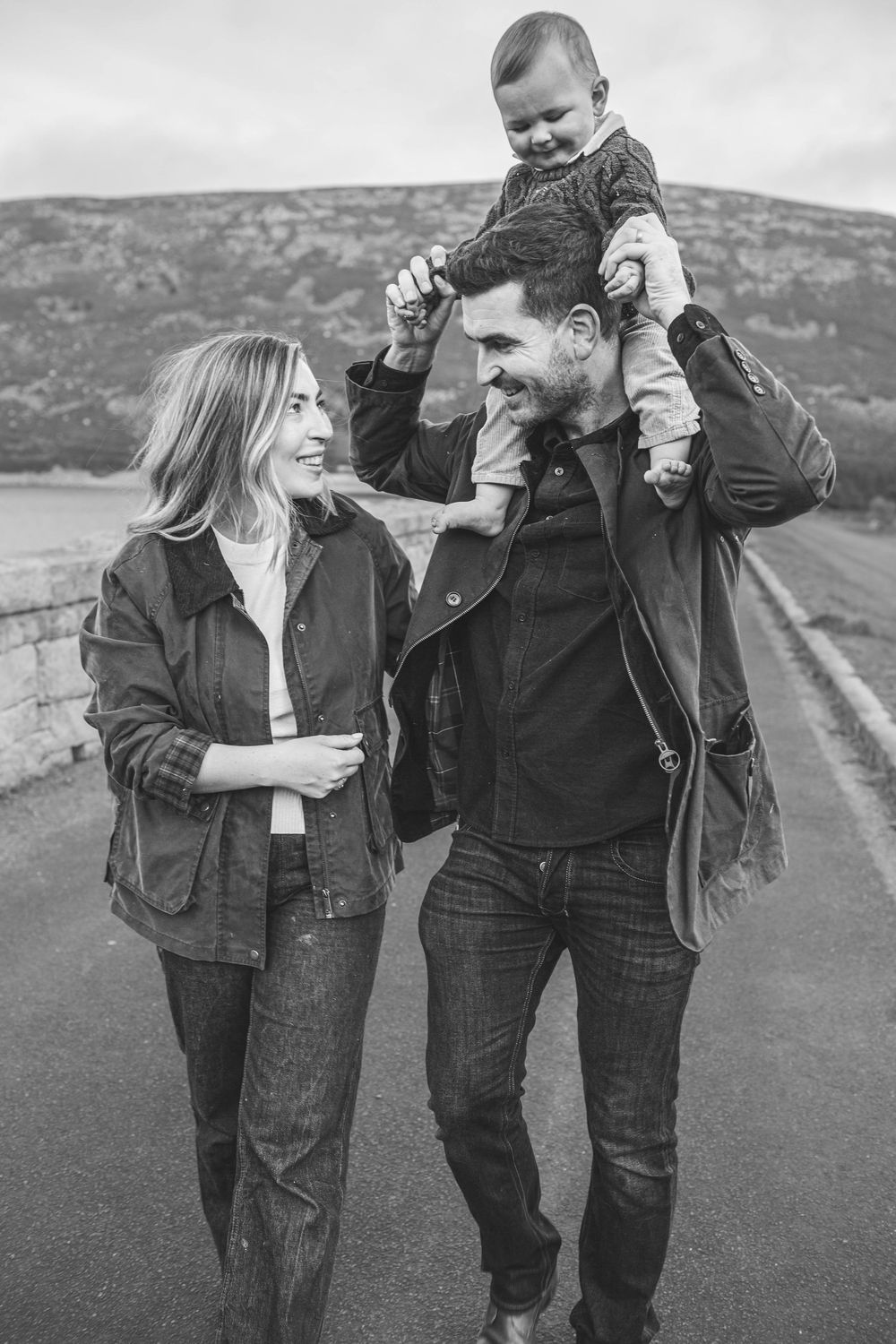 Black and white candid family portrait with mountains in background.
