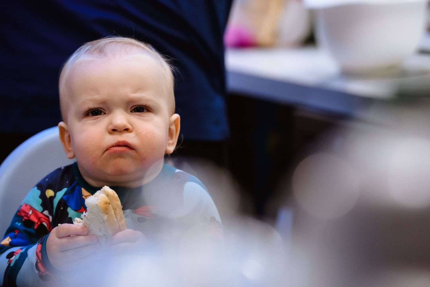 Close up shot of baby eating while wearing a blue bib.