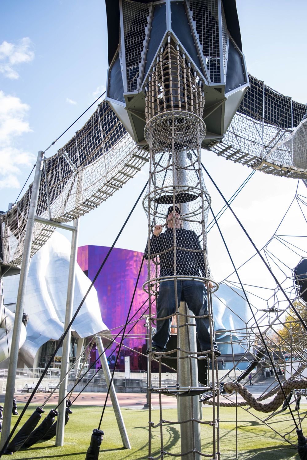 Modern art installation with metallic mesh and geometric structures in an outdoor space.
