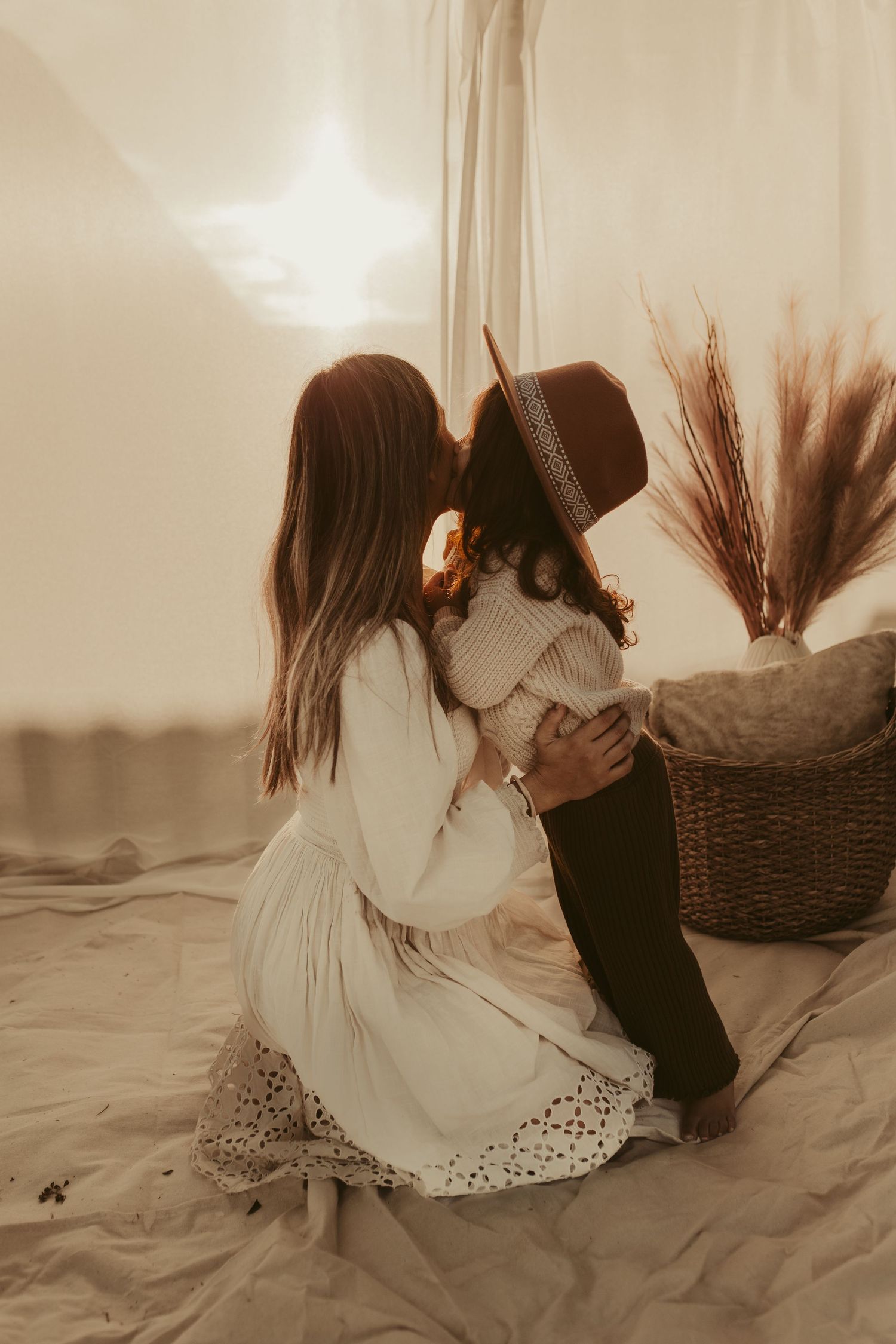 Intimate boho styled portrait with brown hat and pampas grass in sepia tones.