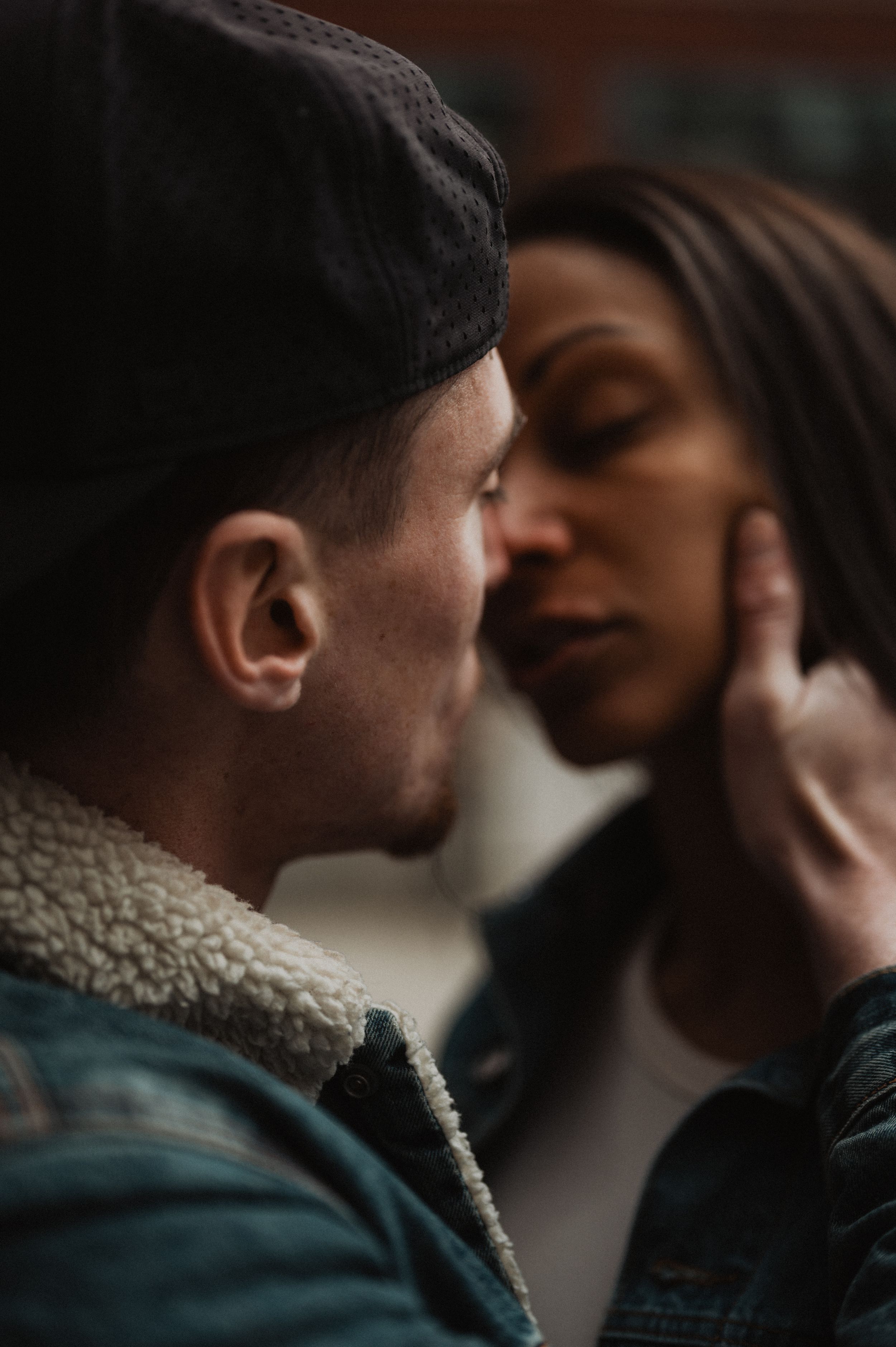 Intimate close-up portrait of couple sharing tender moment in urban setting.
