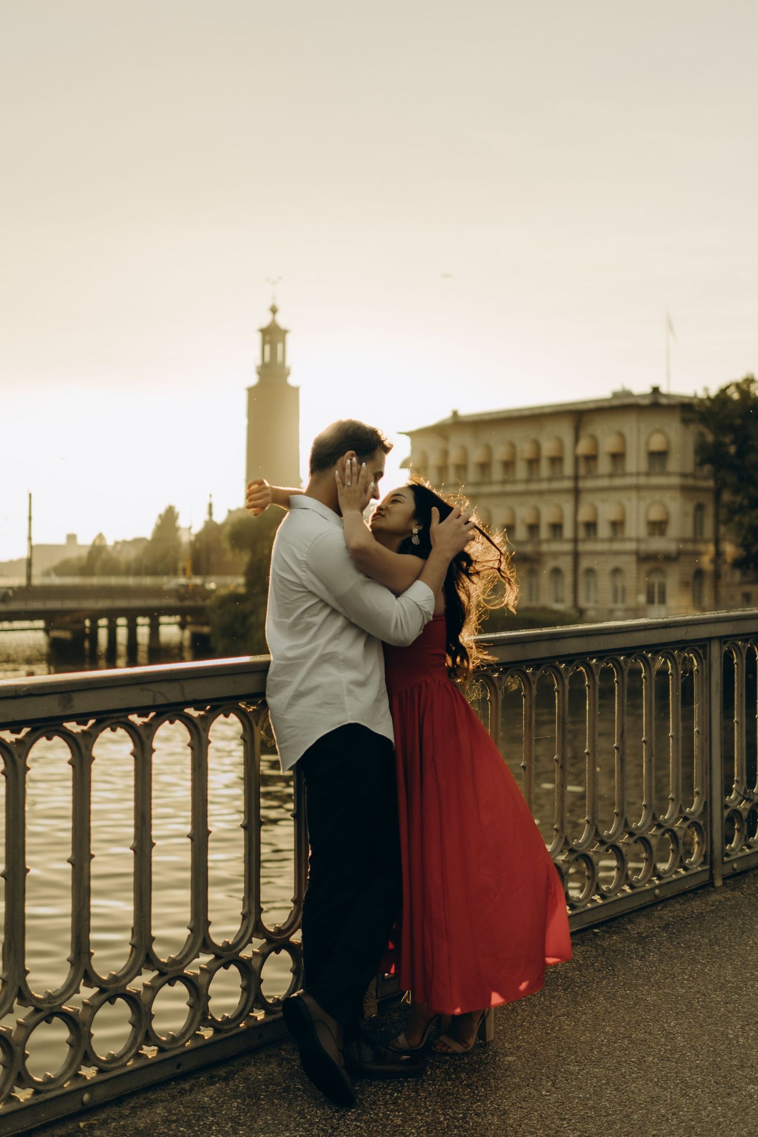 young couple passionately looking at each other with City Hall behind them while being captured by candid couple photographer in Stockholm