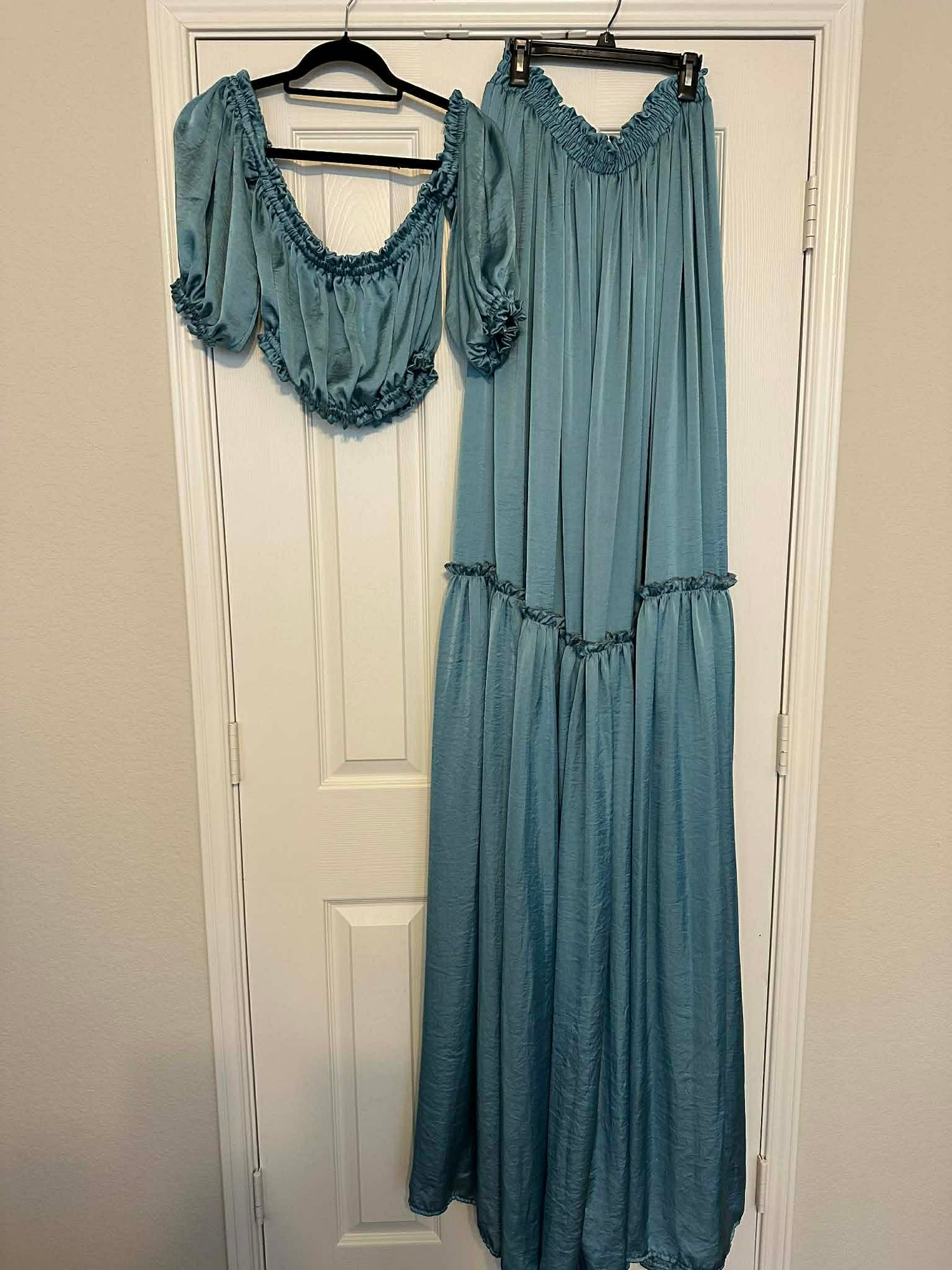 Teal blue two-piece set with ruffled crop top and matching maxi skirt with tiered ruffle detail.