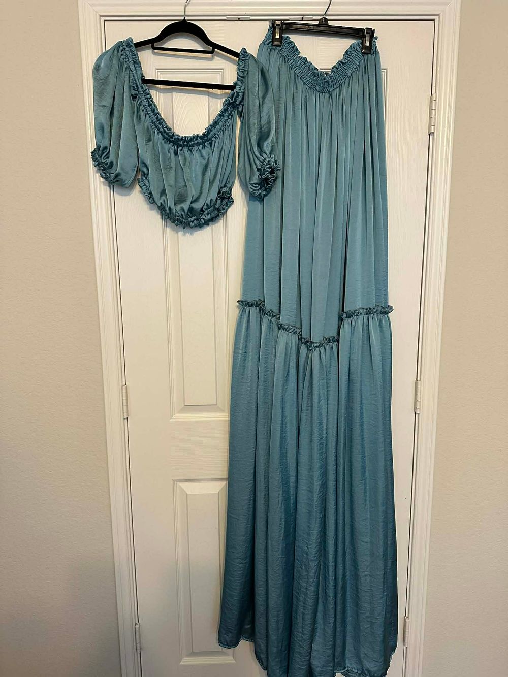 Teal blue two-piece set with ruffled crop top and matching maxi skirt with tiered ruffle detail.
