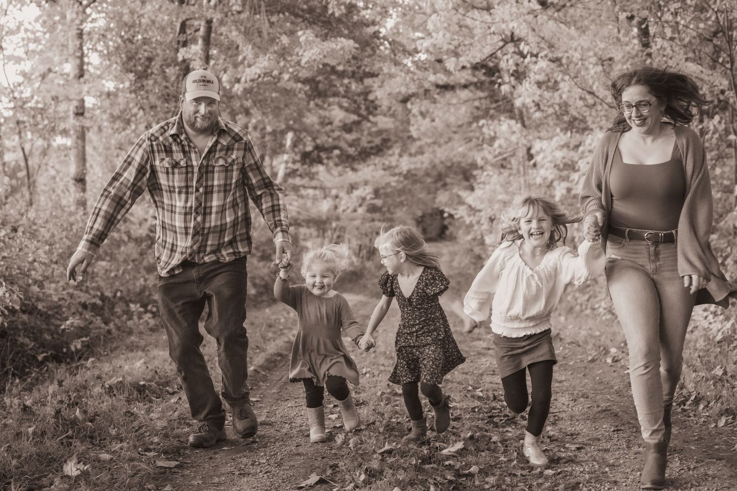family of five running toward camera, 3 little girls, laughing and holding hands, happiness.