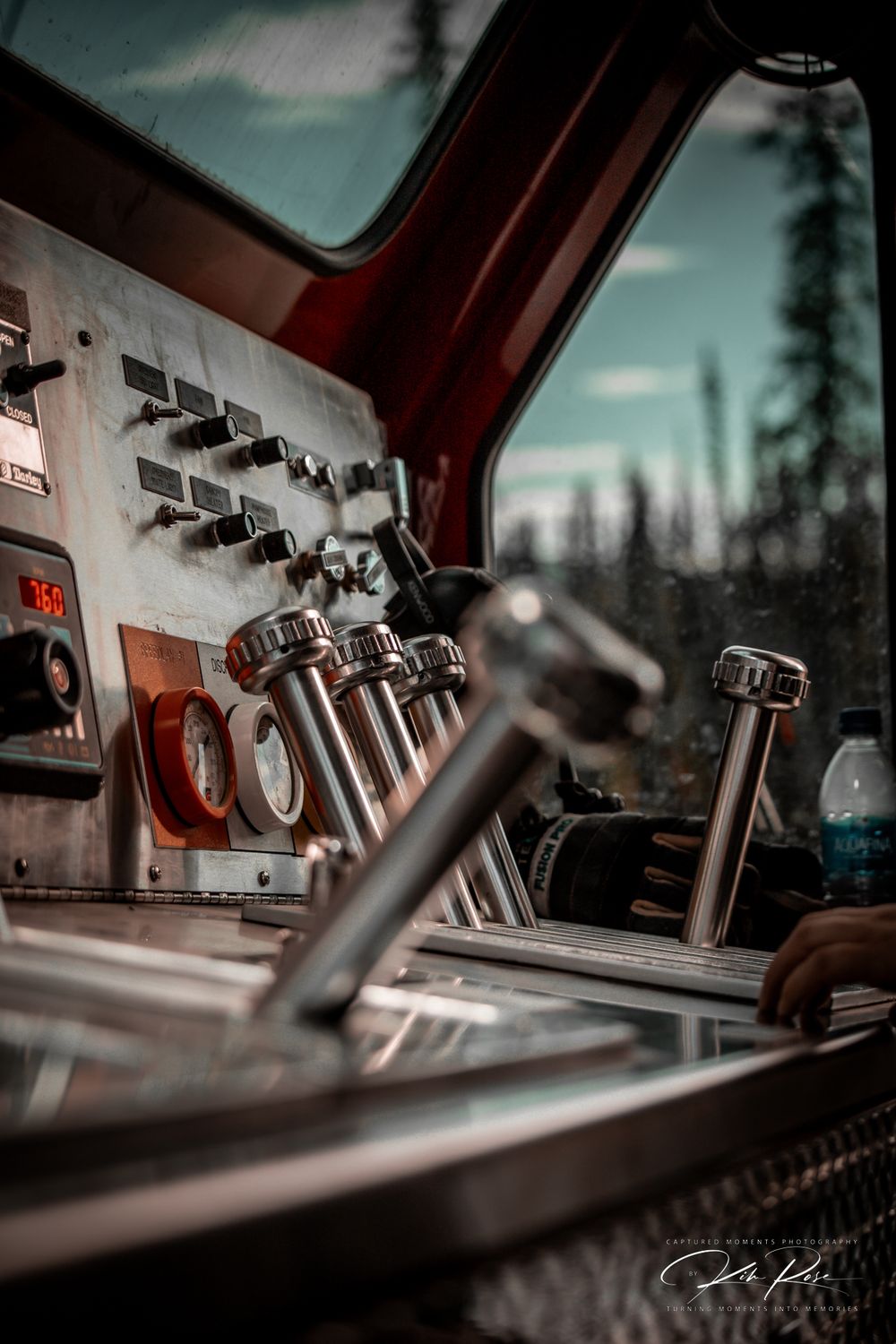 Close-up of a fire truck control panel with chrome levers and gauges inside the cab.