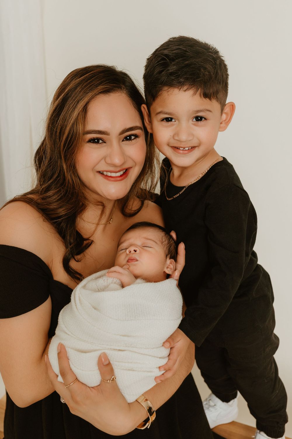 Studio portrait against white background with infant in white wrap.
