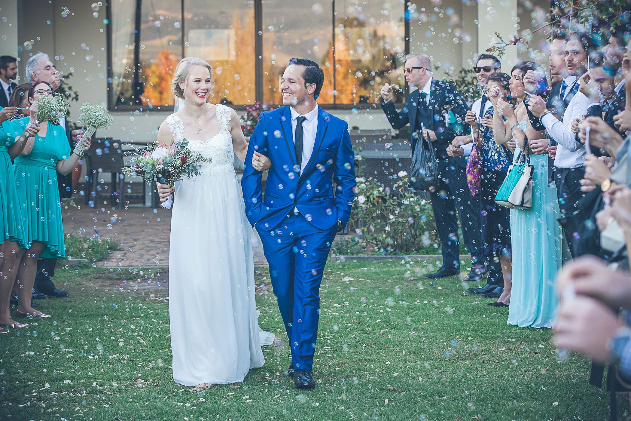 Ryan & Linnaea joyously walk down an aisle of bubbles on their wedding day at Vredenheim Wine Estate, Stellenbosch