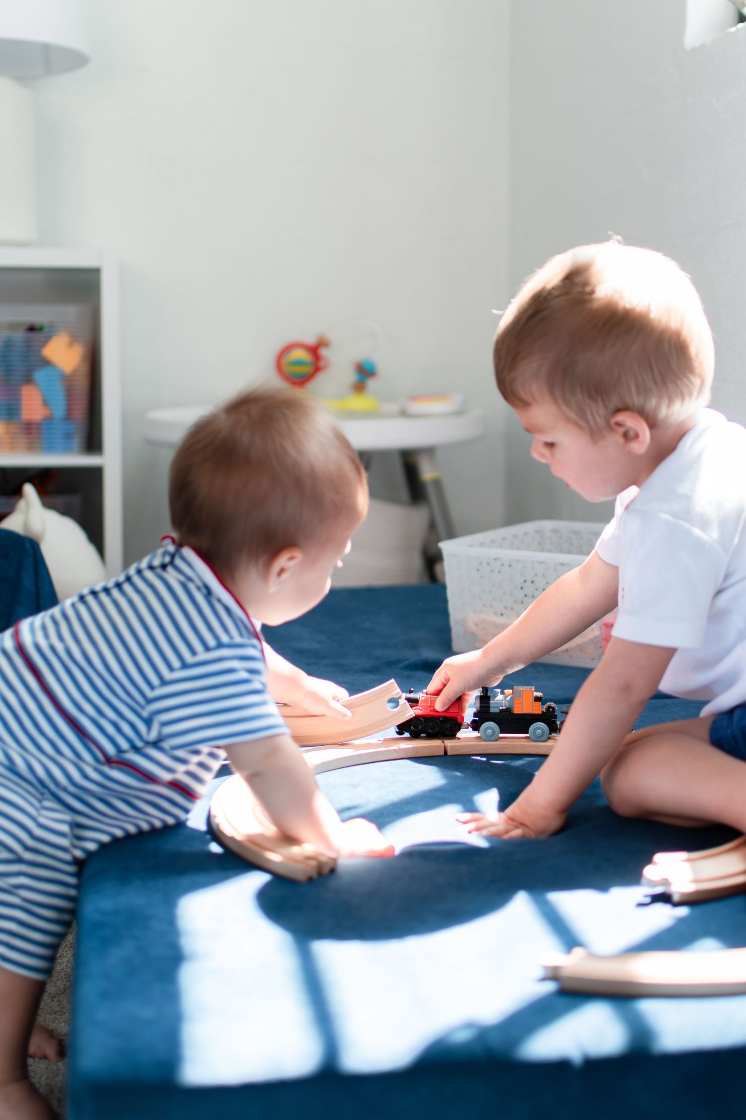 Two brothers play with their train tracks in their light-filled basement in Ardmore.