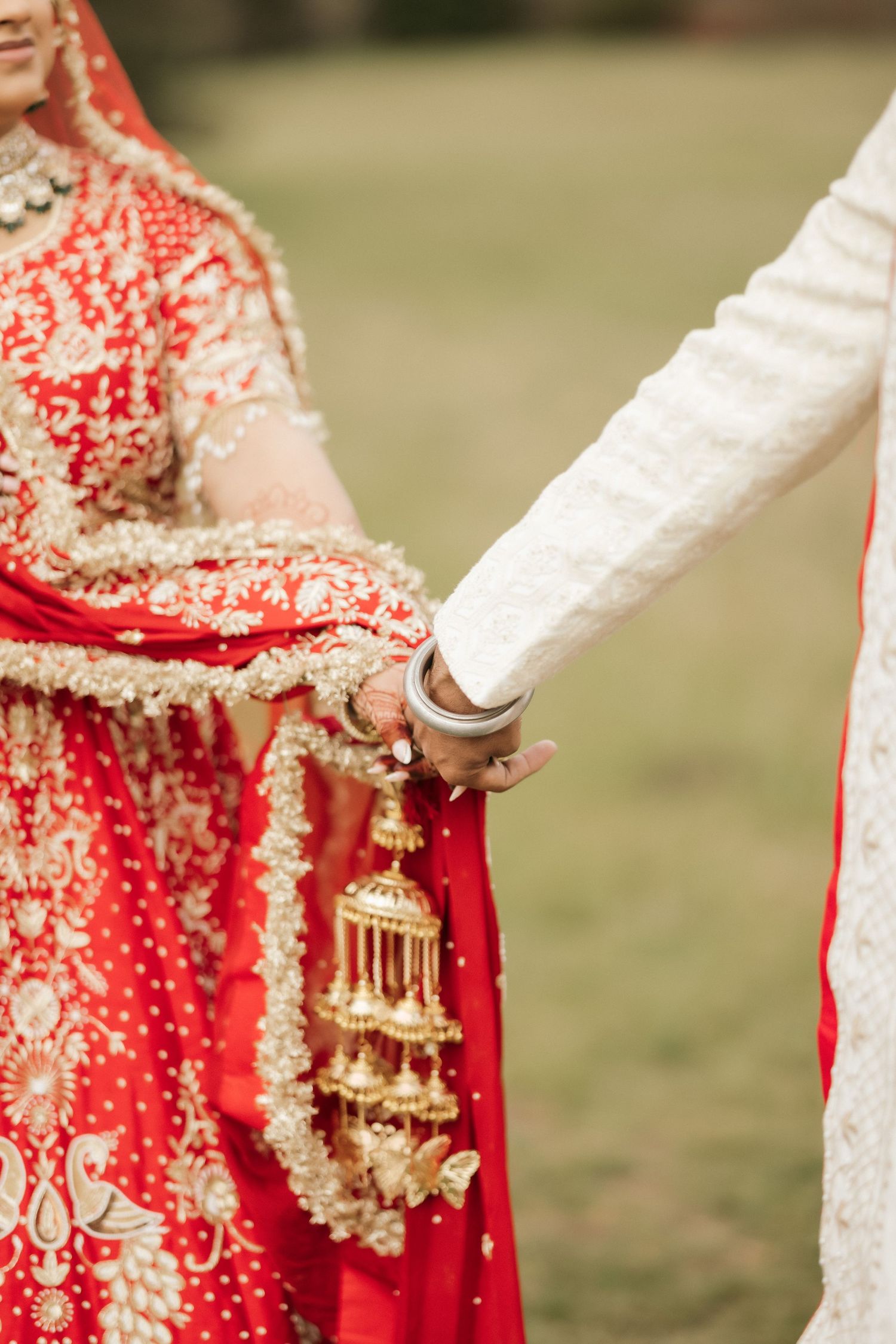 Close-up detail of traditional Indian wedding attire showing intricate red and white designs.