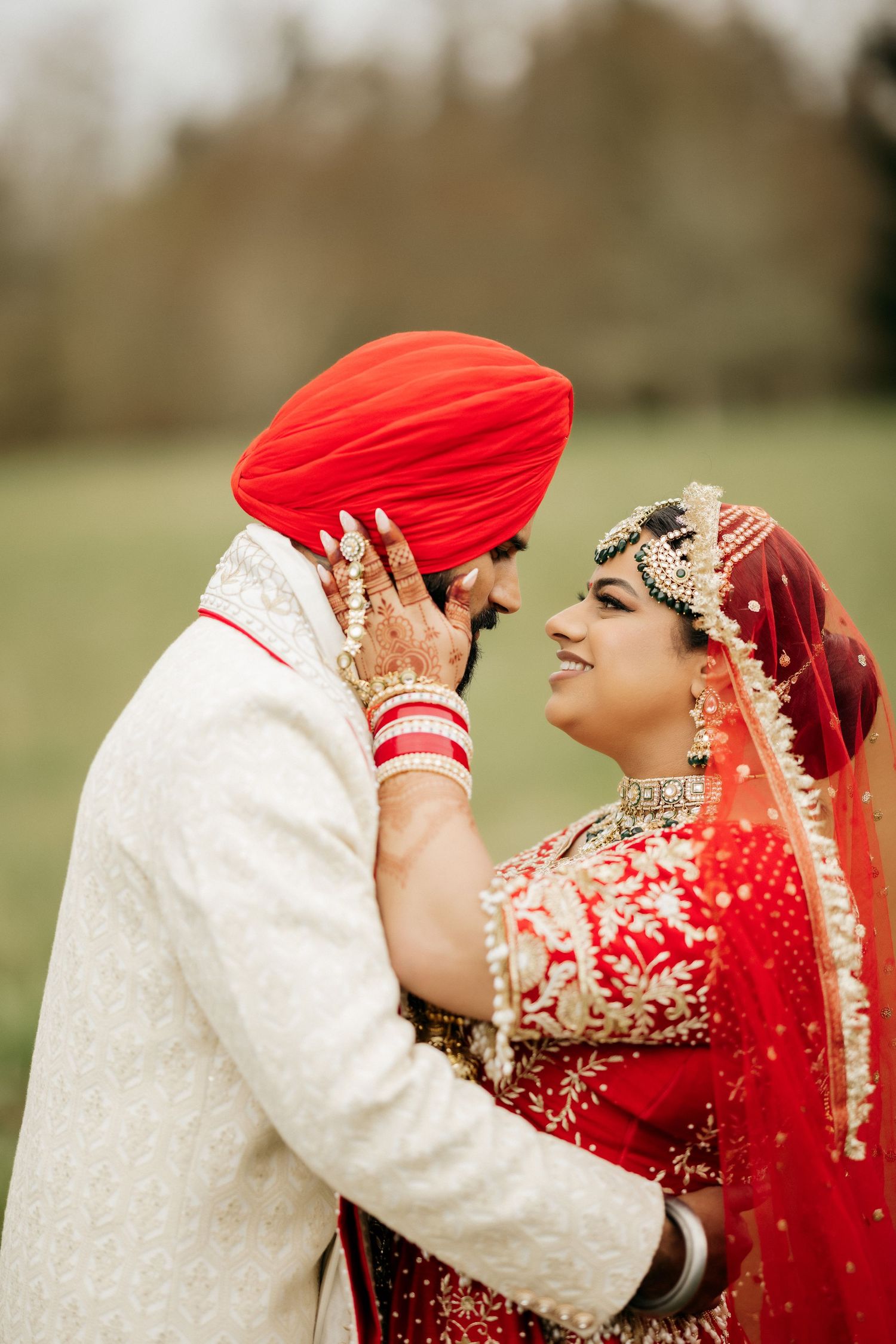Close-up of traditional Sikh wedding couple sharing intimate moment outdoors.