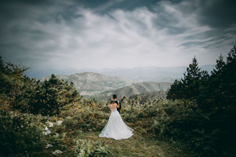 Postboda en Asturias en plena montaña, pareja abrazada rodeada de bosque con vistas abiertas al paisaje desde el Mirador del Fito.