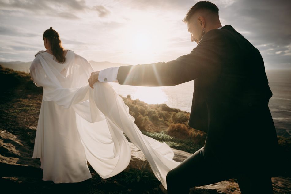 Novios al atardecer realizando reportaje de Post Boda en el Cabo Vidio en Cudillero, Asturias