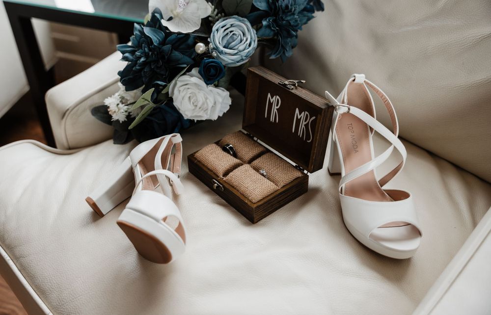 Wedding detail shot of blue and white flowers with elegant accessories.