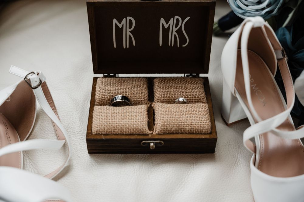 Flat lay of wedding rings and text boxes arranged with neutral decor items.