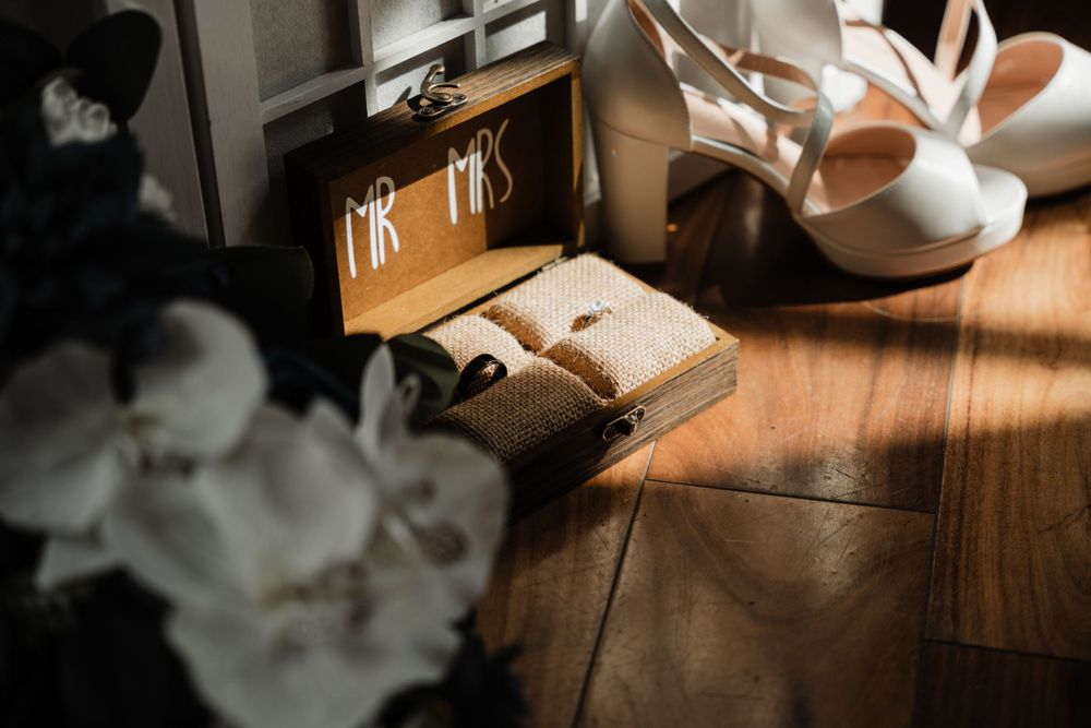 Moody wedding detail photography of rings and accessories in natural window light.