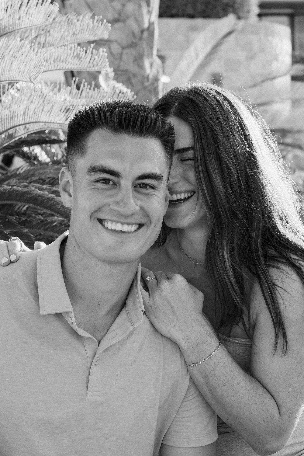 Couple sharing an intimate black and white portrait moment outdoors.