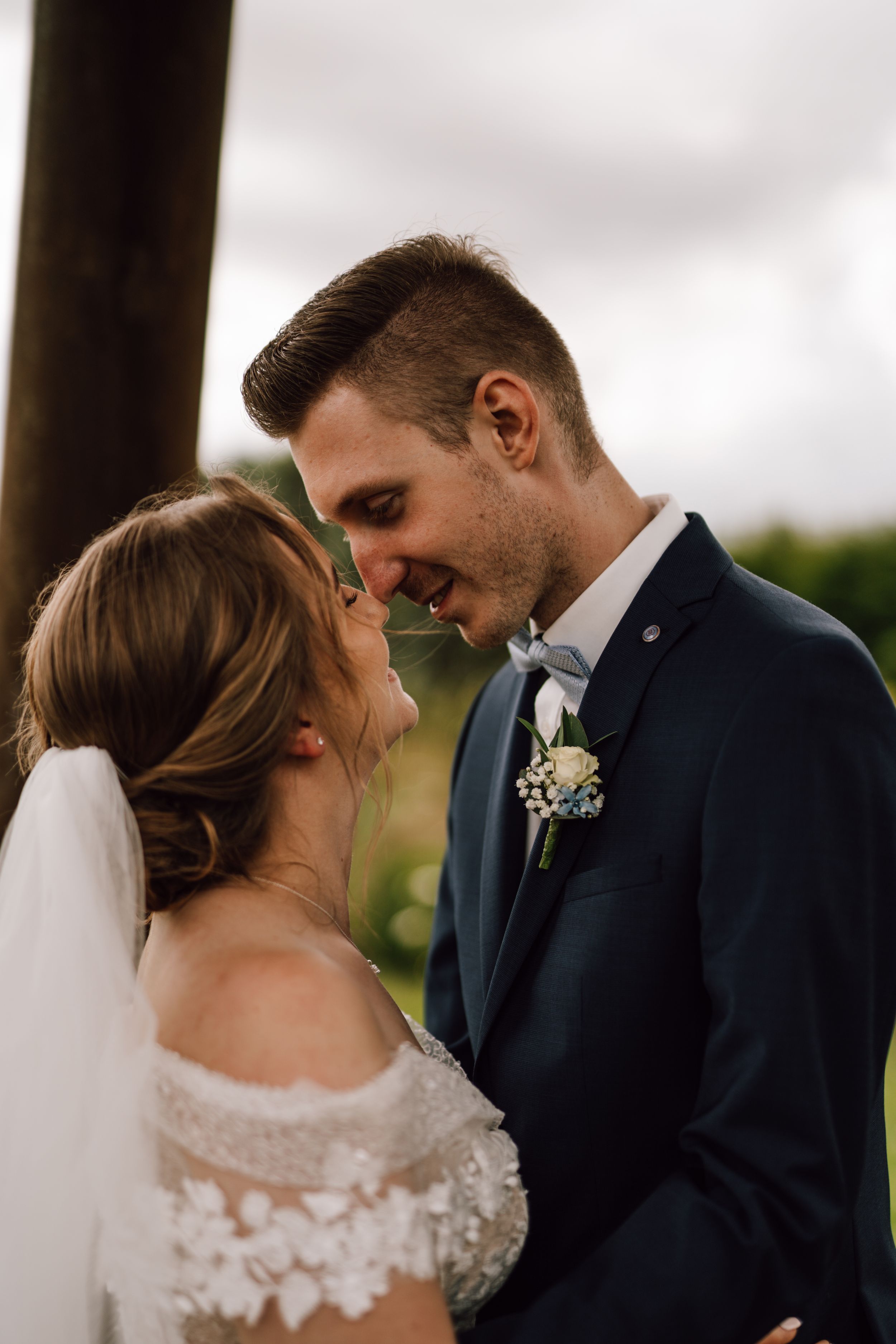 An intimate moment between newlyweds sharing a close embrace outdoors.