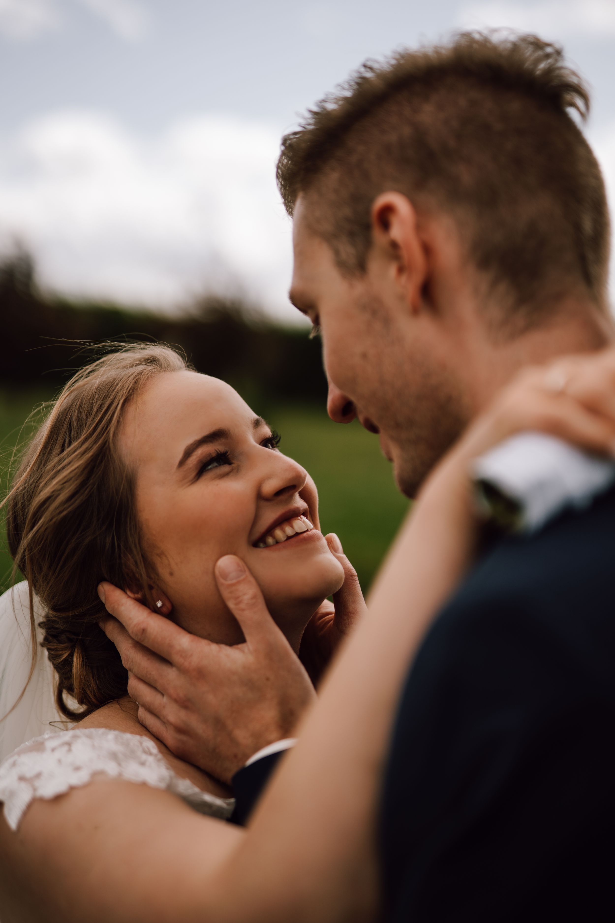 Close-up wedding portrait showing genuine emotion and joy against a natural backdrop.