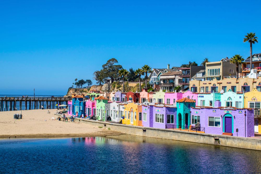 Row of vibrant pastel-colored beach houses along the California coast.