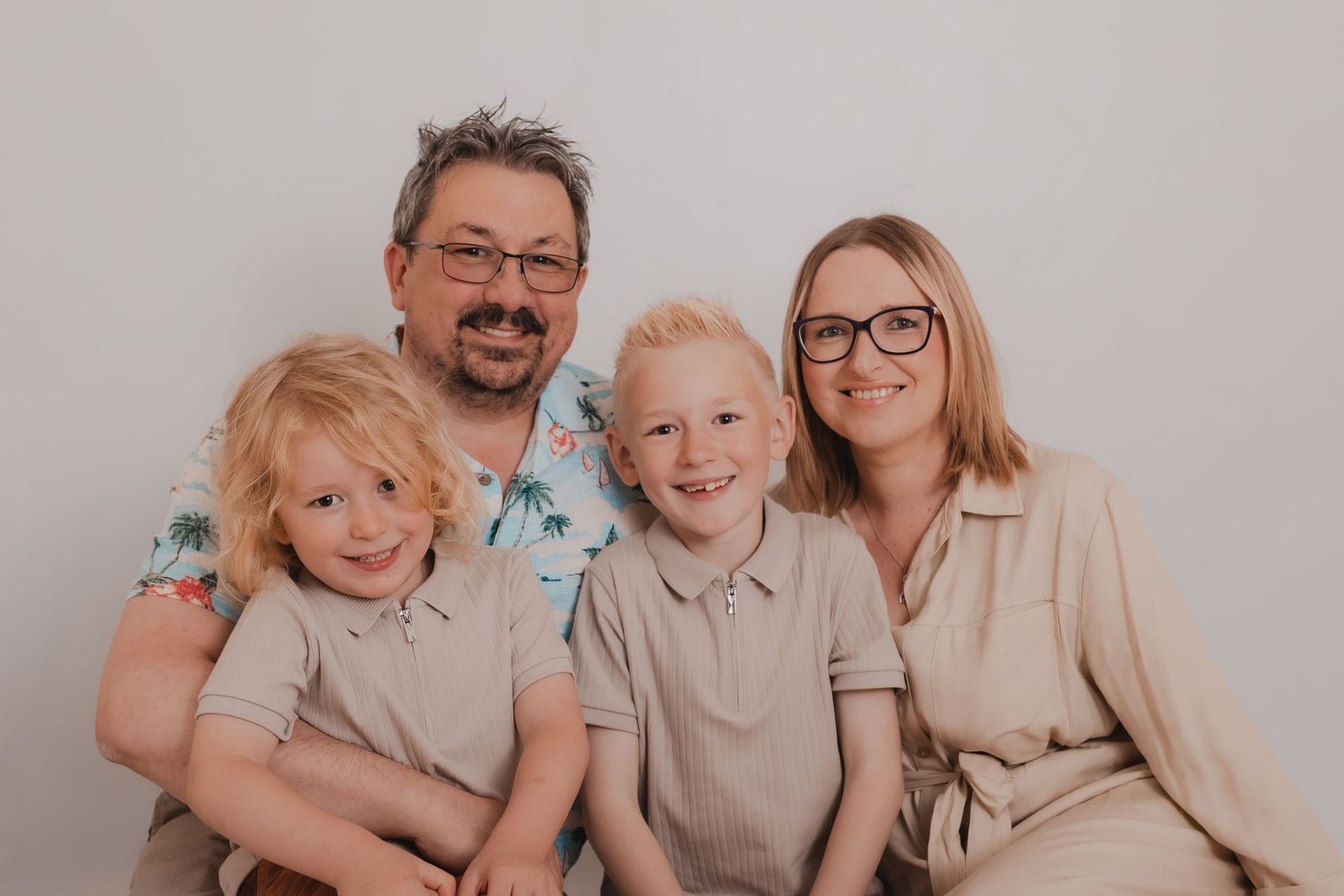 Family portrait with coordinated beige outfits against white background. Photographer. Hull. East Yorkshire. Photography