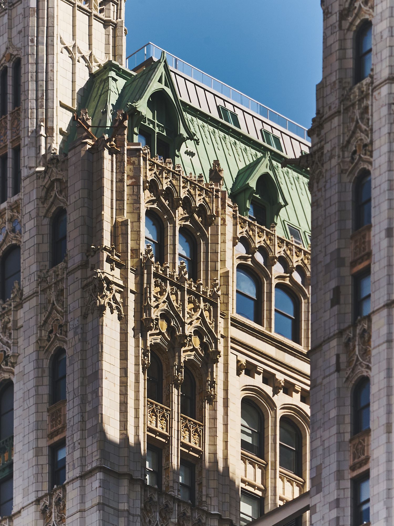 Ornate Gothic architectural details adorn the facade of a historic cathedral with green copper roofing.