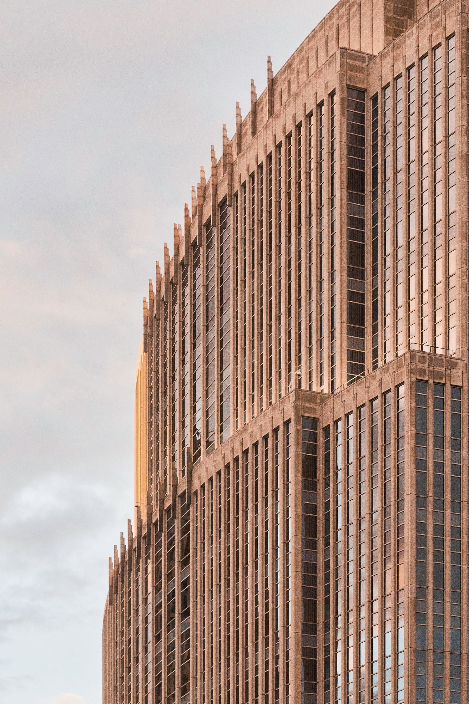 Modern office building exterior with vertical architectural lines during sunset.