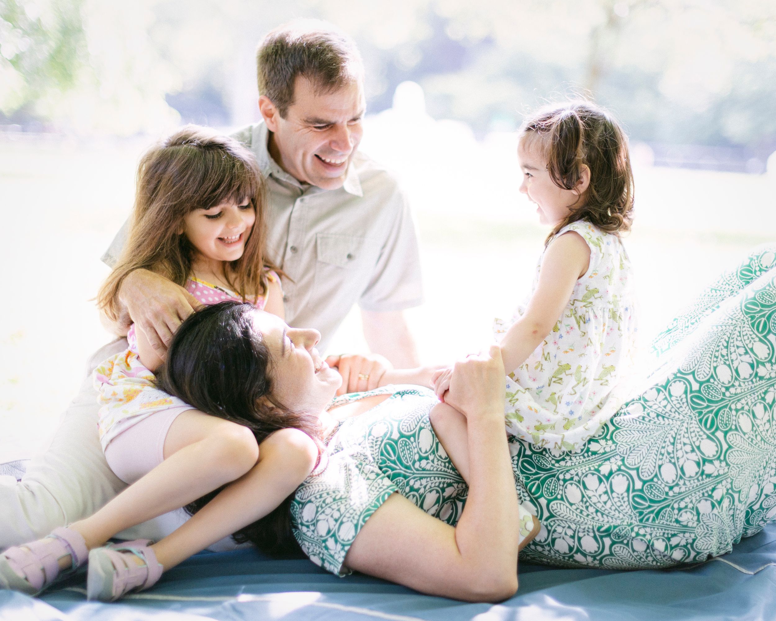 A joyful family moment captured in soft light as they play and laugh together.