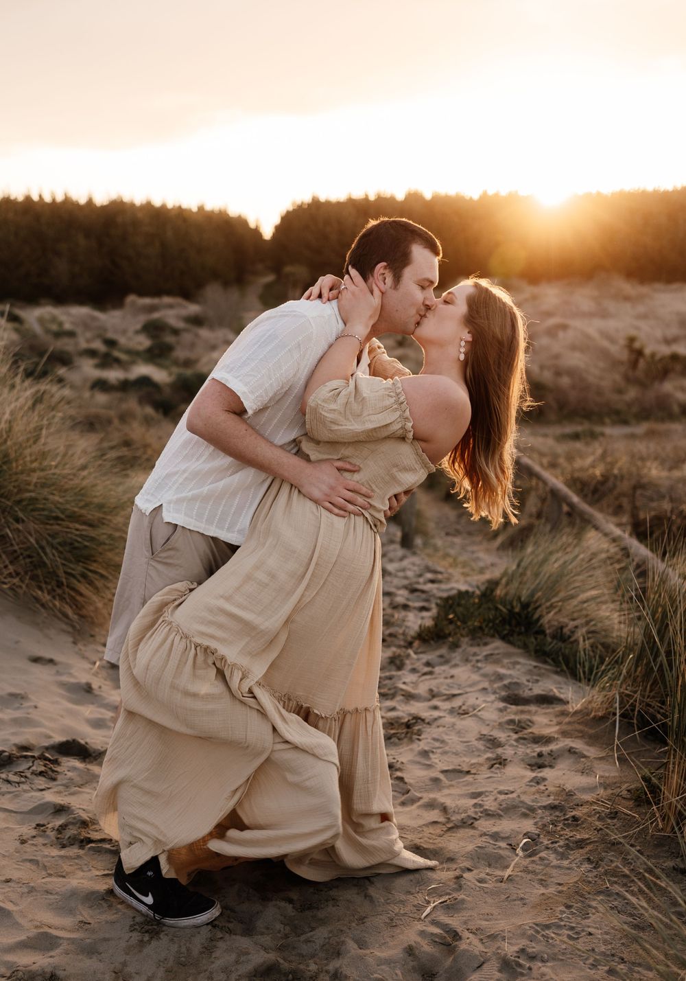 Couple kissing at sunset golden hour beach candid