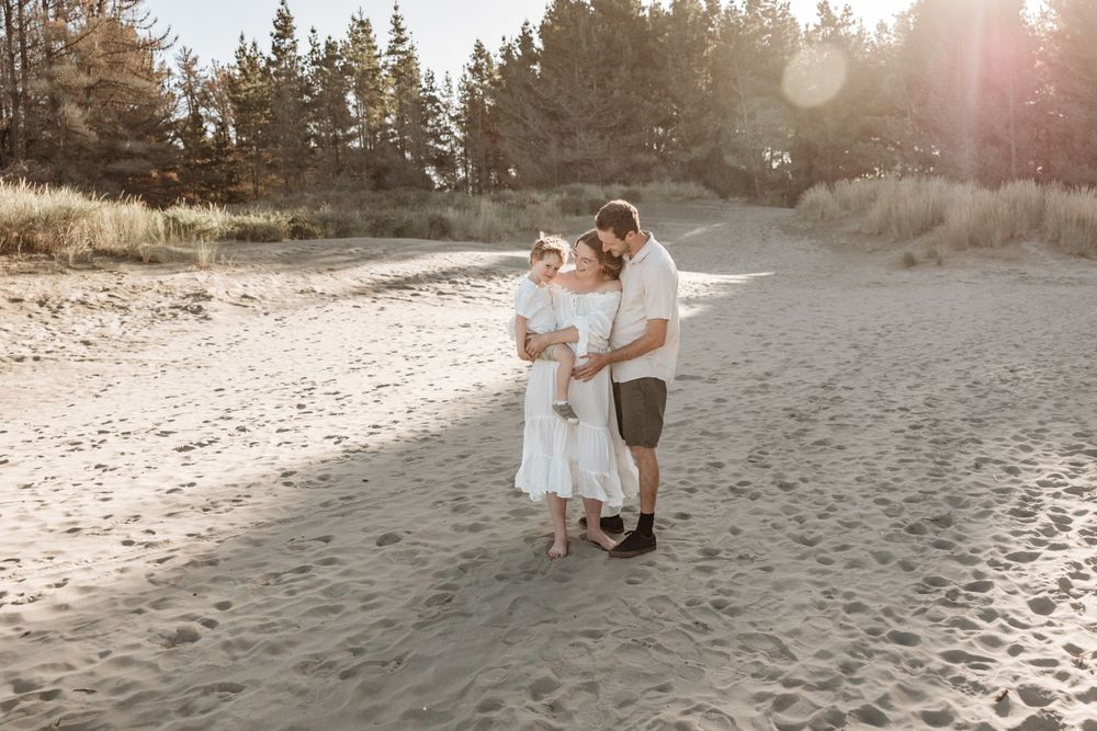 Family of 3 pregnant mother on beach