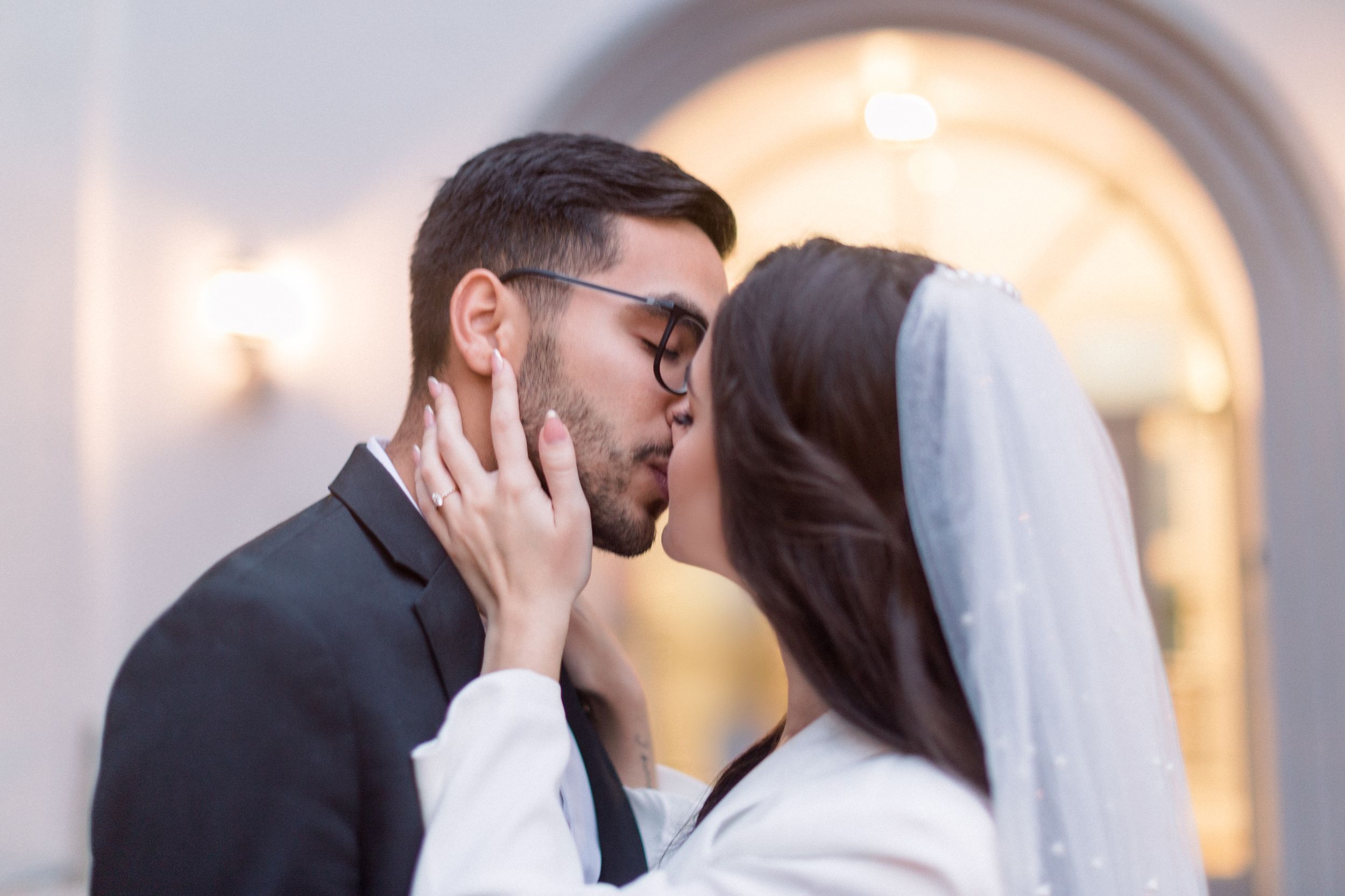 A romantic moment shared between couple under arched doorway.