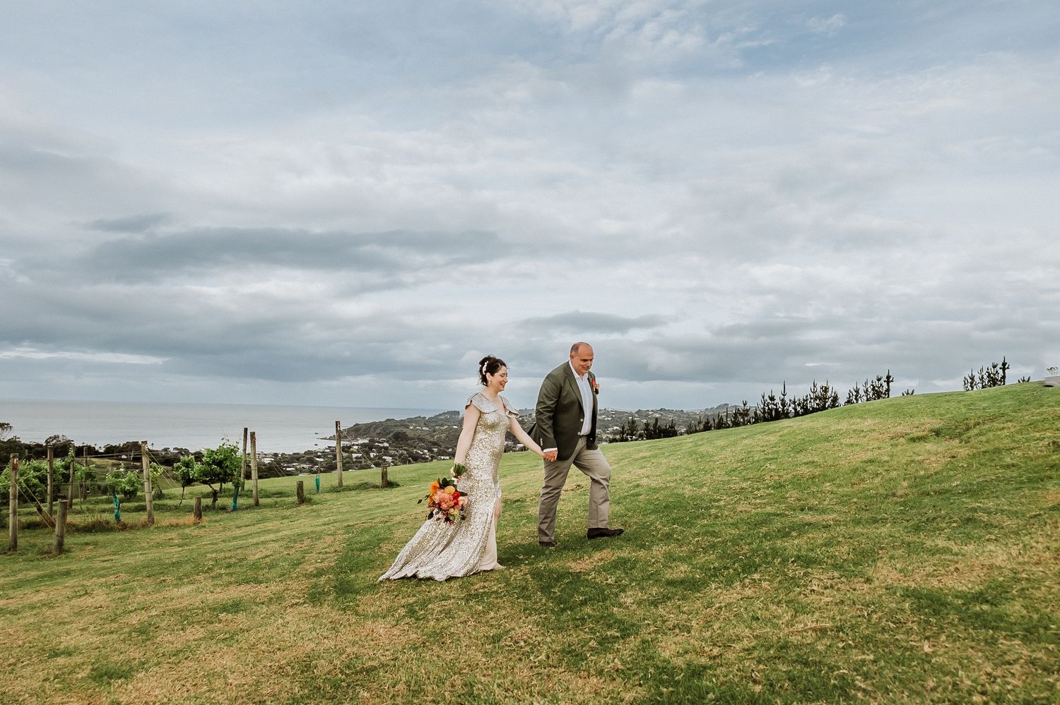 Bride and Groom Walking at the vineyard at Mudbrick Waiheke wedding venue. Wedding photographer